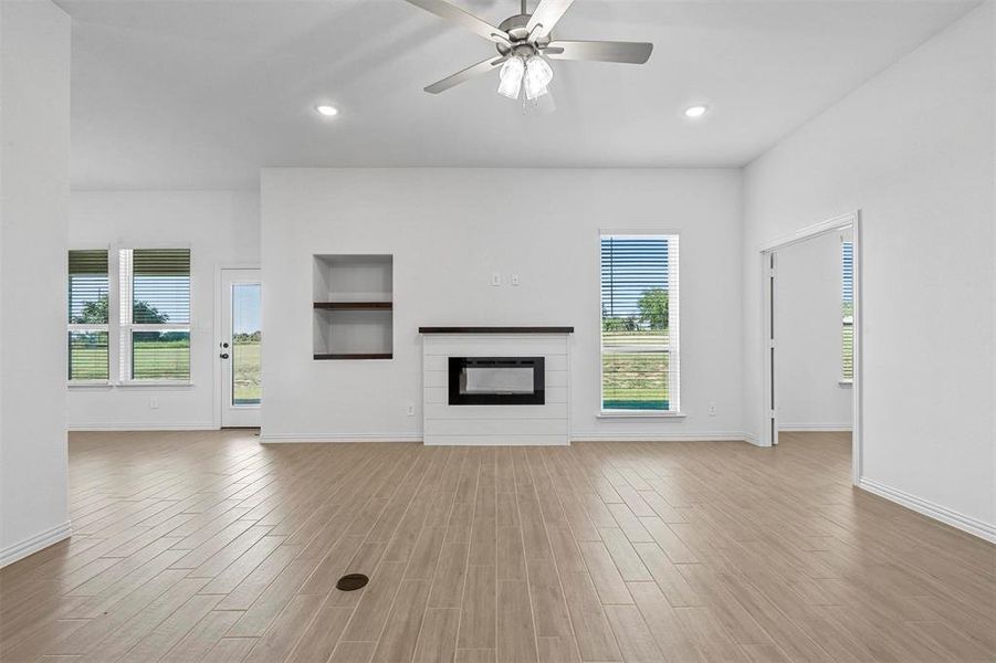 Unfurnished living room with light hardwood / wood-style floors and ceiling fan