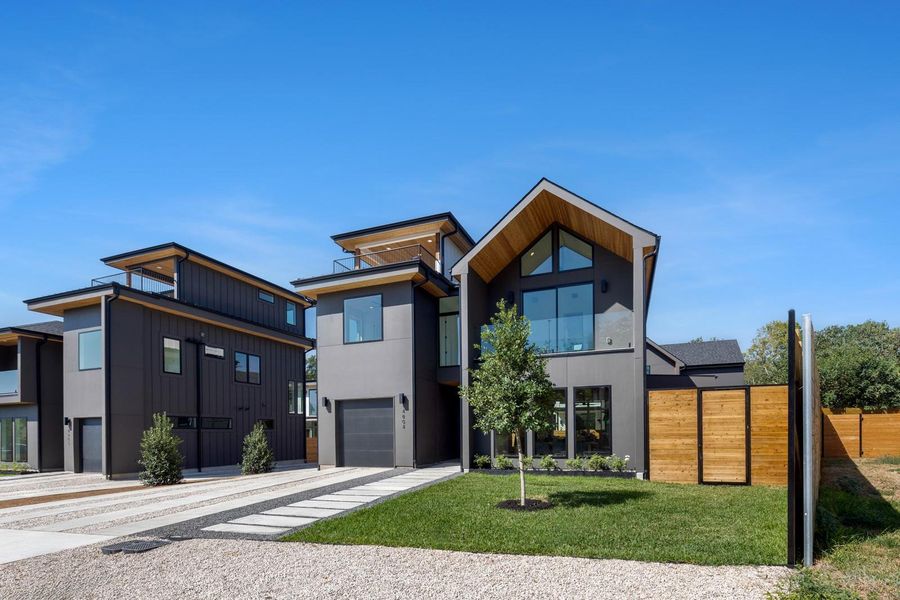 Contemporary home featuring driveway, a balcony, an attached garage, and stucco siding Contemporary home featuring driveway, a balcony, an attached garage, and stucco siding