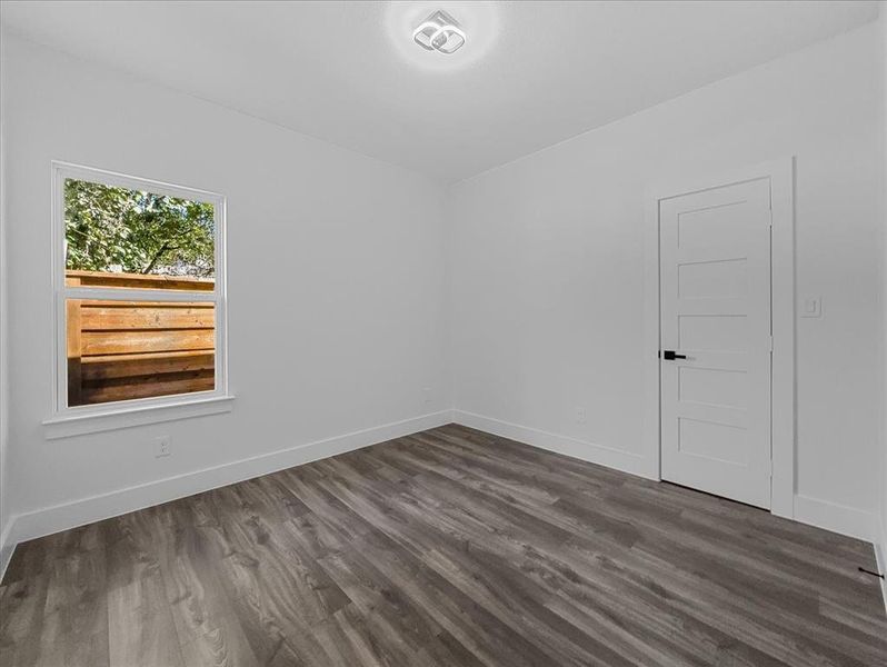 Empty room featuring dark wood-style floors and baseboards Empty room featuring dark wood-style floors and baseboards
