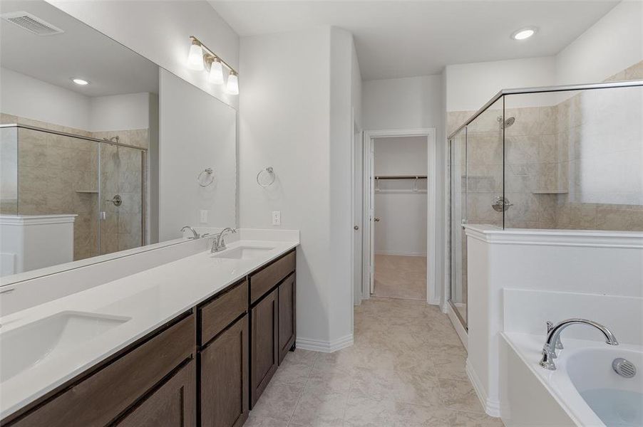 Bathroom with dual vanities featuring dark wood cabinetry and white countertops