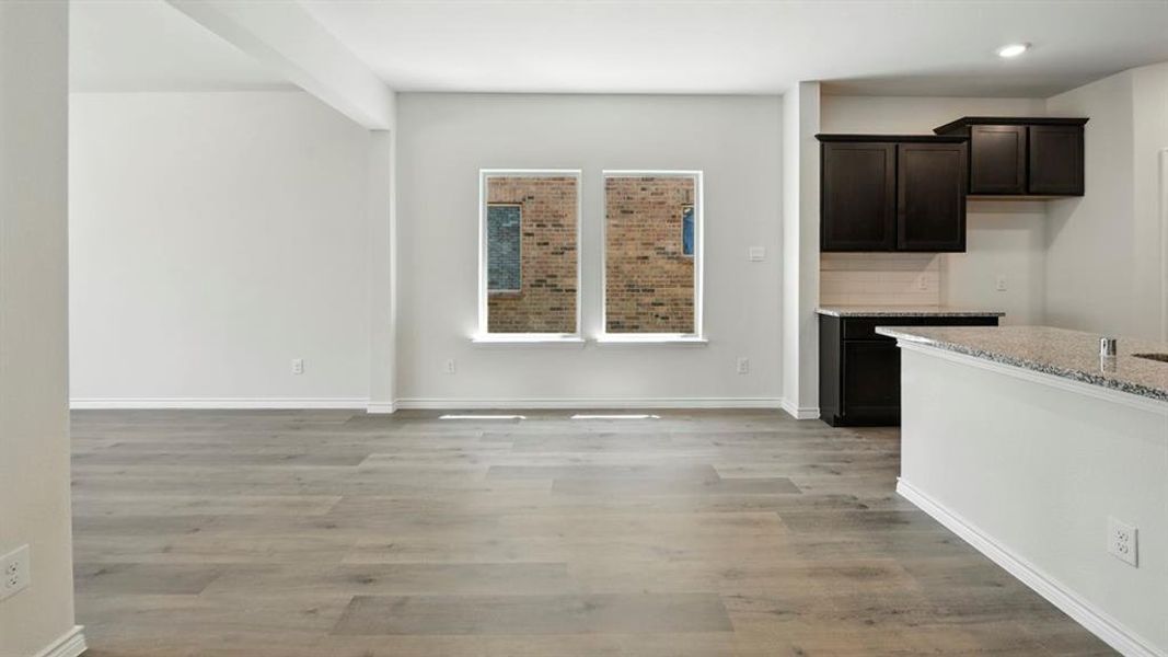 Unfurnished dining area featuring light wood finished floors and baseboards