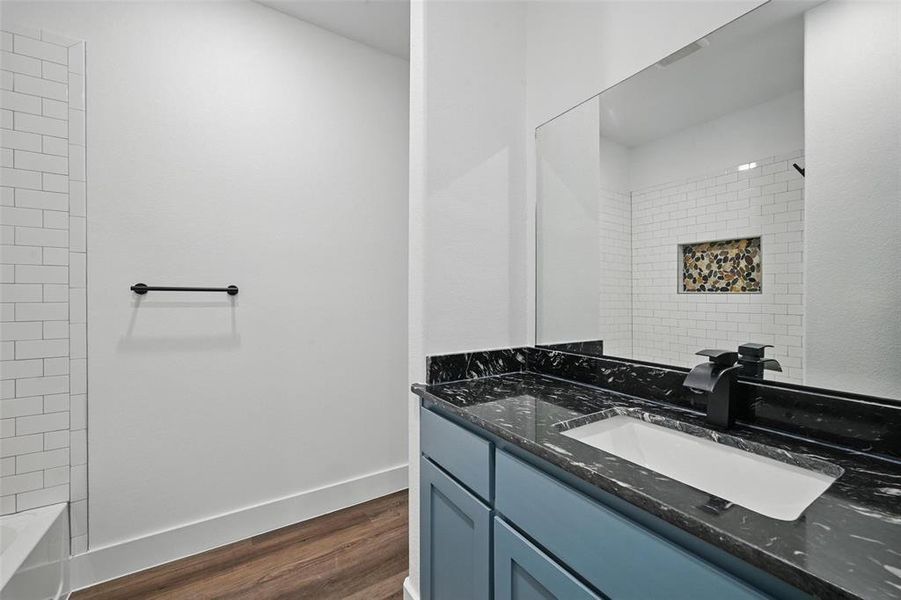 Bathroom with wood finished floors, vanity, and baseboards