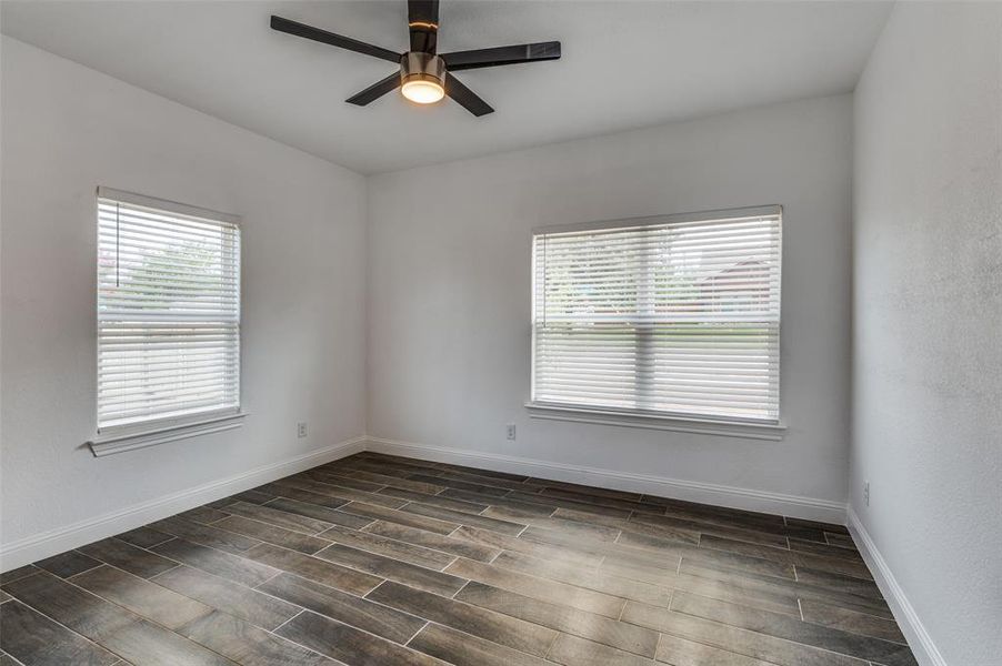 Unfurnished room with plenty of natural light, wood tiled floors, and ceiling fan Unfurnished room with plenty of natural light, wood tiled floors, and ceiling fan
