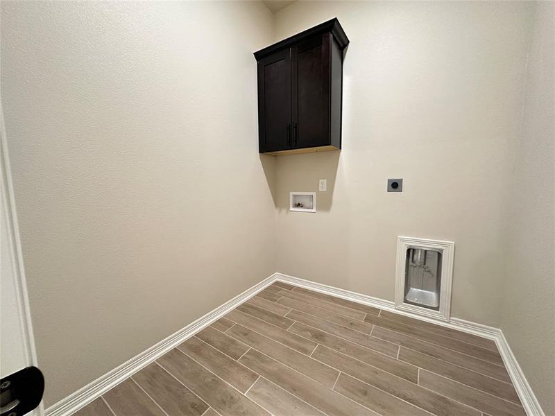 Laundry room with wood tiled floors, electric dryer hookup, cabinet space, and hookup for a washing machine
