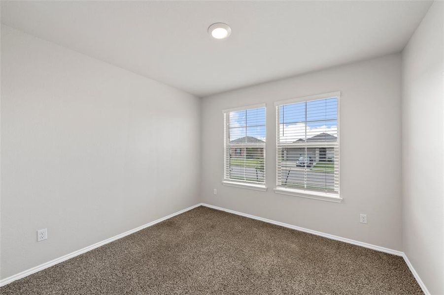 Spare room featuring dark carpet and baseboards Spare room featuring dark carpet and baseboards