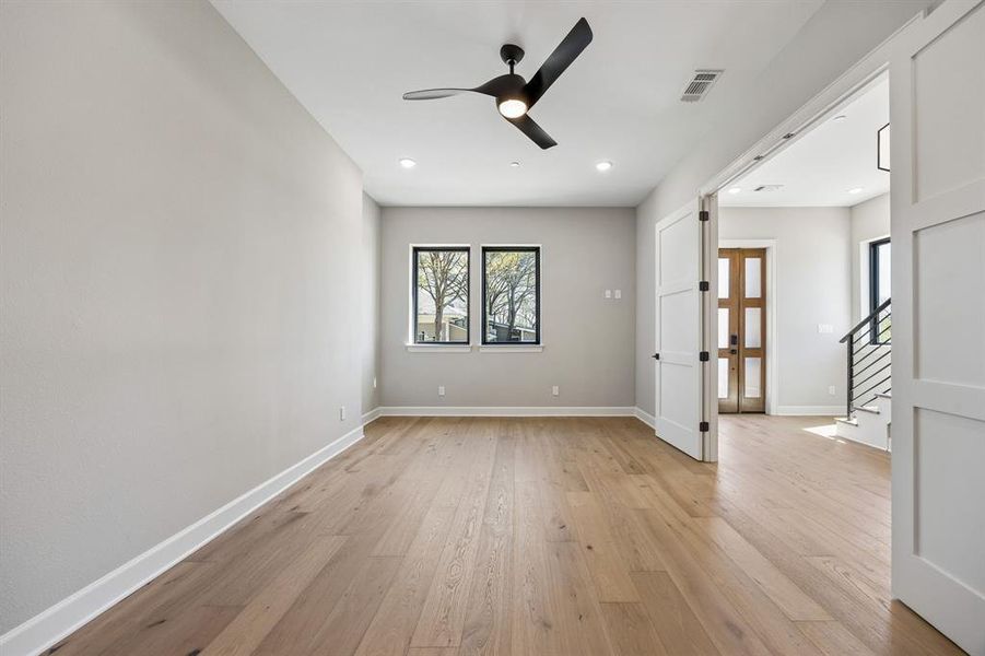 Empty room with a ceiling fan, light wood-style flooring, and recessed lighting Empty room with a ceiling fan, light wood-style flooring, and recessed lighting