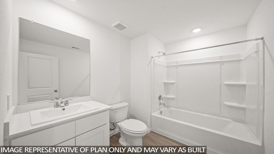A well-lit, functional bathroom features a single vanity, modern toilet, and a combined shower-bathtub unit.