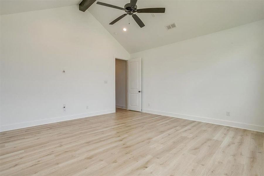 Unfurnished room featuring light wood-type flooring, ceiling fan, high vaulted ceiling, and beamed ceiling