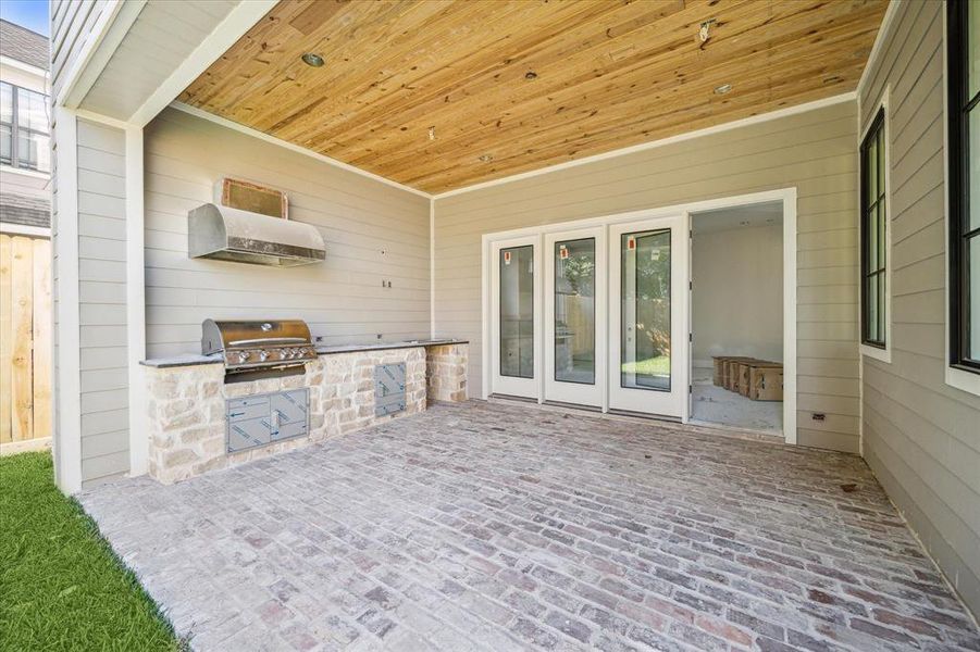 Outdoor covered patio with outdoor kitchen. Estimated completion date of construction - January 15, 2025.