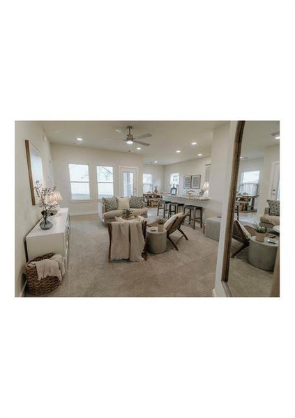 Living room with ceiling fan and light carpet