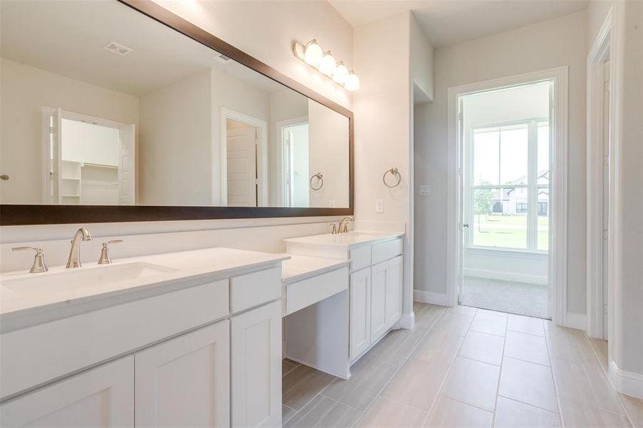 Bathroom with double sink vanity and tile patterned flooring