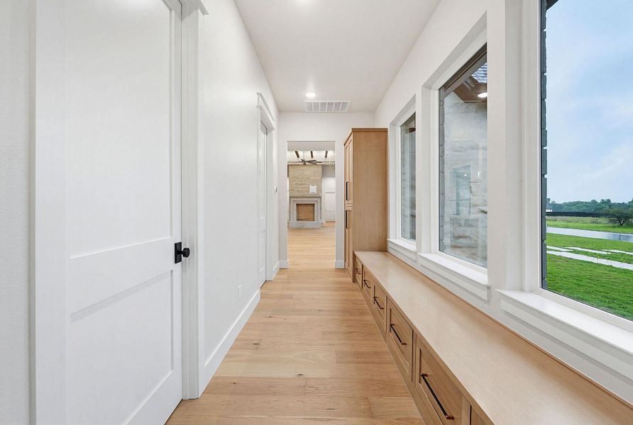 Hallway featuring light wood-finish flooring, white walls, and recessed lighting