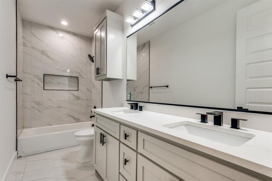 Bathroom featuring light marble finish flooring, double vanity, and tub / shower combination Bathroom featuring light marble finish flooring, double vanity, and tub / shower combination
