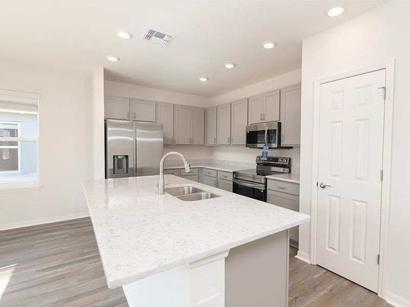 Enjoy a sunny, open kitchen with an island and walk-in pantry - Blakely by Highland Homes