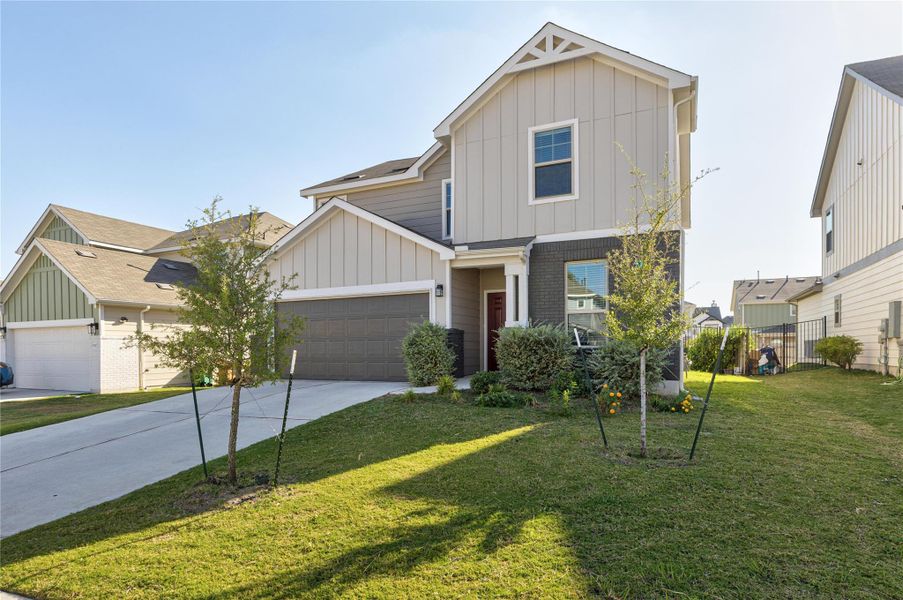 View of front of house featuring board and batten siding, driveway, and a garage