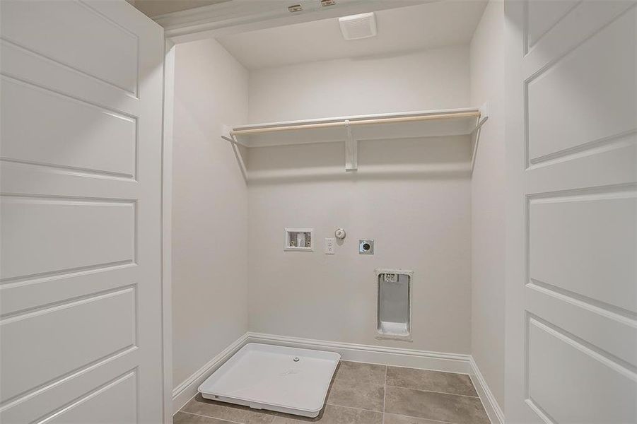 Laundry room featuring gas dryer hookup, hookup for an electric dryer, light tile patterned floors, and washer hookup Laundry room featuring gas dryer hookup, hookup for an electric dryer, light tile patterned floors, and washer hookup