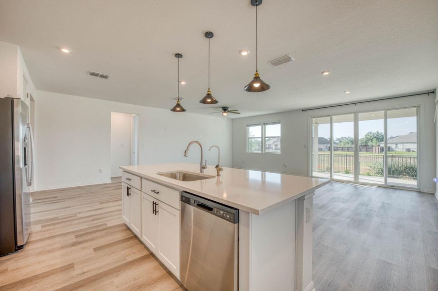 An open floor plan seamlessly connects the modern kitchen and airy living area.