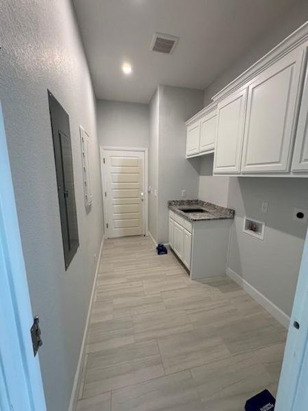 Laundry room with cabinet space, hookup for a washing machine, and recessed lighting