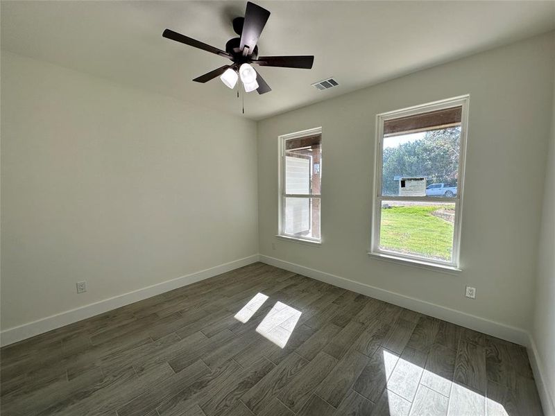 Unfurnished room with ceiling fan and dark hardwood / wood-style floors