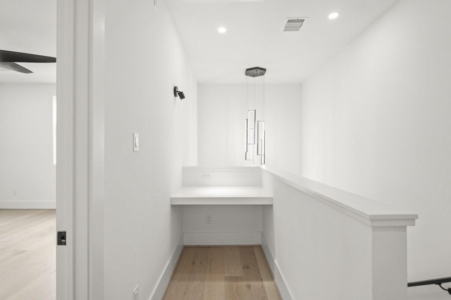 The third floor built-in desk area features a modern black light fixture offering a comfortable spot for late night work or study.