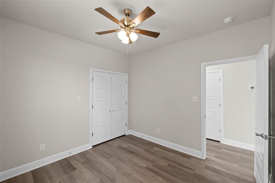 Unfurnished room with hardwood / wood-style flooring and ceiling fan