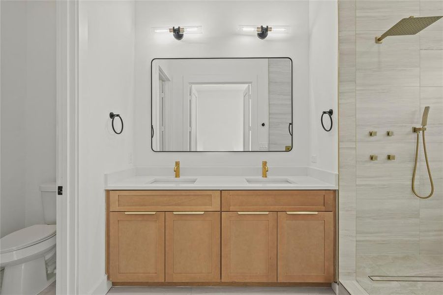 Full bathroom with tiled shower and double vanity