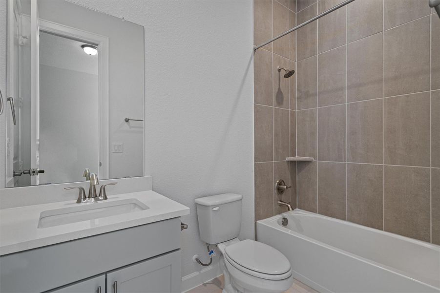 Full bathroom featuring vanity, bathtub / shower combination, and a textured wall Full bathroom featuring vanity, bathtub / shower combination, and a textured wall