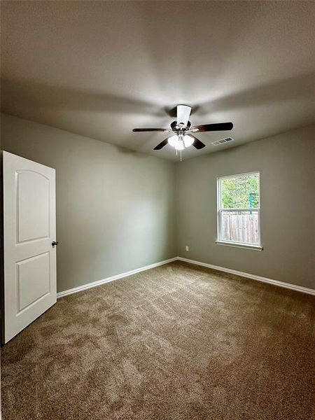 Spare room featuring dark carpet and ceiling fan