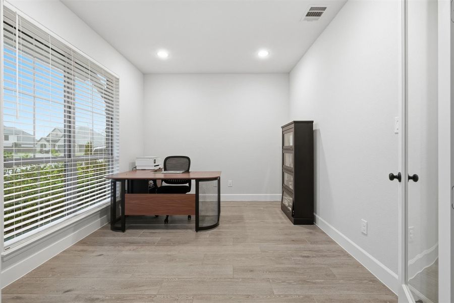 This photo showcases a bright, modern home office with large windows, wood flooring, and minimalist decor. The space includes a sleek desk, office chair, and a storage cabinet, all set against neutral walls, providing a functional and inviting workspace. This photo showcases a bright, modern home office with large windows, wood flooring, and minimalist decor. The space includes a sleek desk, office chair, and a storage cabinet, all set against neutral walls, providing a functional and inviting workspace.