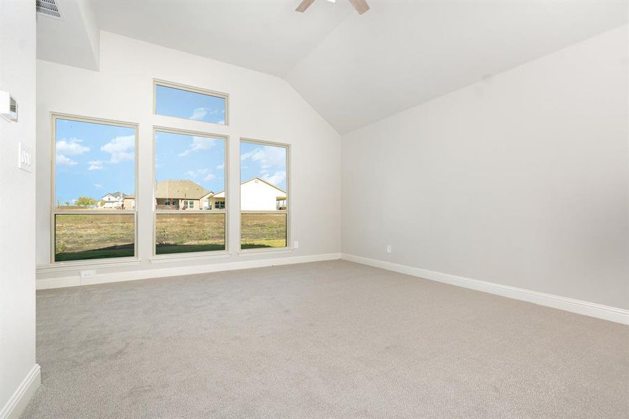 Unfurnished room with vaulted ceiling, light carpet, and a ceiling fan