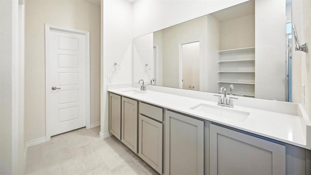 Bathroom with double vanity and light tile patterned floors