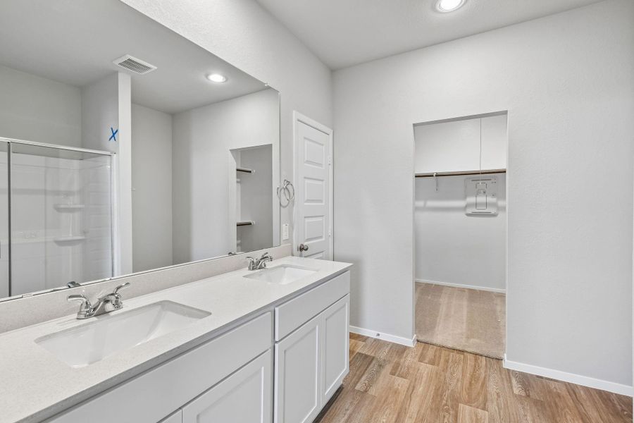 The primary bathroom features a spacious and well-designed layout, centered around both comfort and functionality.