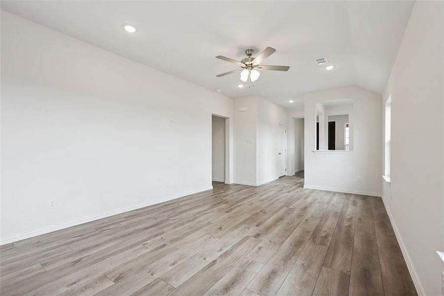 Unfurnished room with light wood-type flooring, recessed lighting, a ceiling fan, and vaulted ceiling