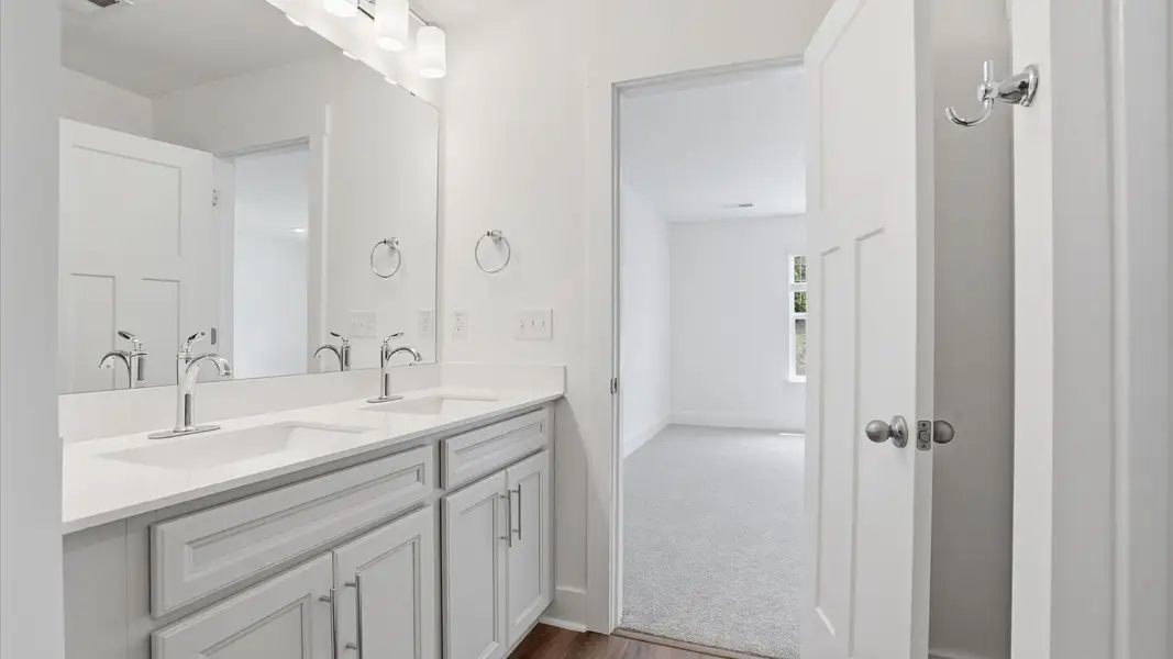 Accomplished design shines in this primary bath with dual vanity and a sleek walk-in shower located in Greenville, SC