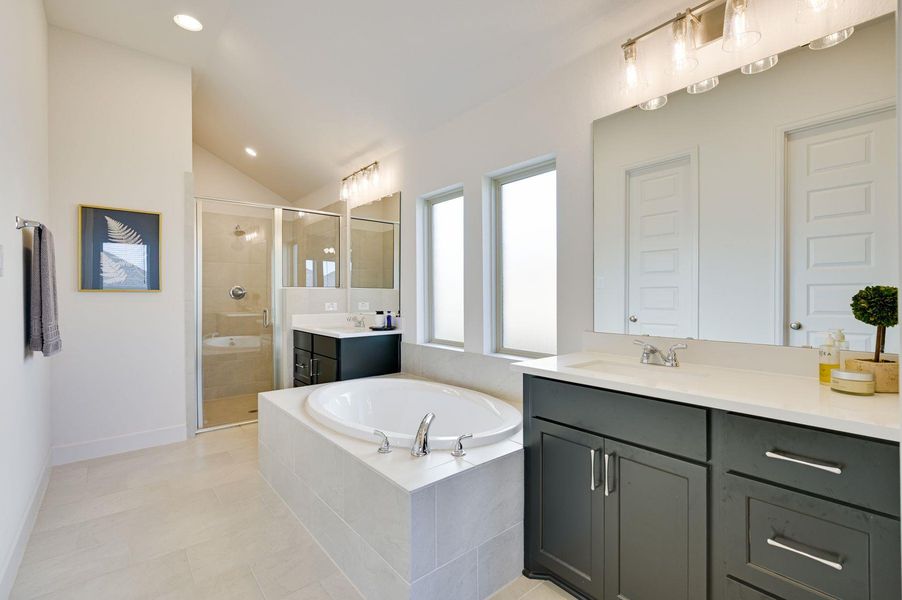 Primary bathroom with double vanities, soaking tub, and a large walk-in shower.