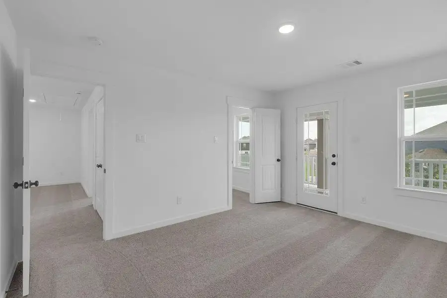 Each bedroom boasts generous square footage, and this bedroom features a cozy covered balcony.