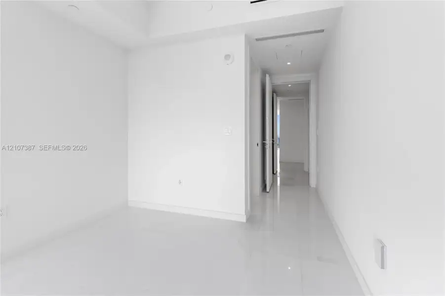 Neutral interior featuring high-gloss tile flooring, recessed ceiling lighting, and smooth-finish walls