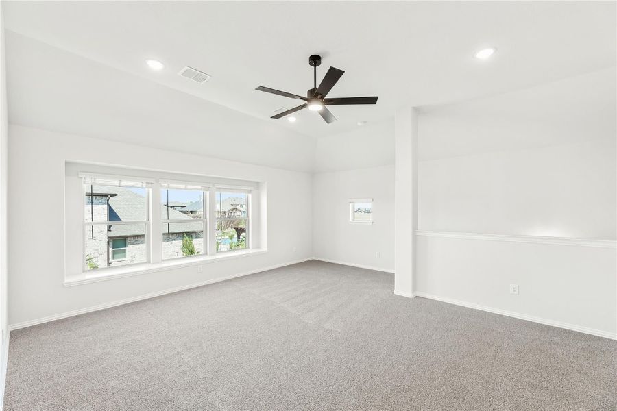 Empty room with gray carpet, ceiling fan, recessed lighting, and large windows with neighborhood view