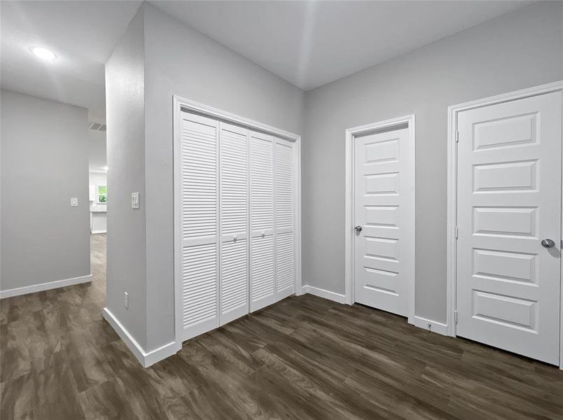 Unfurnished bedroom with dark wood-type flooring