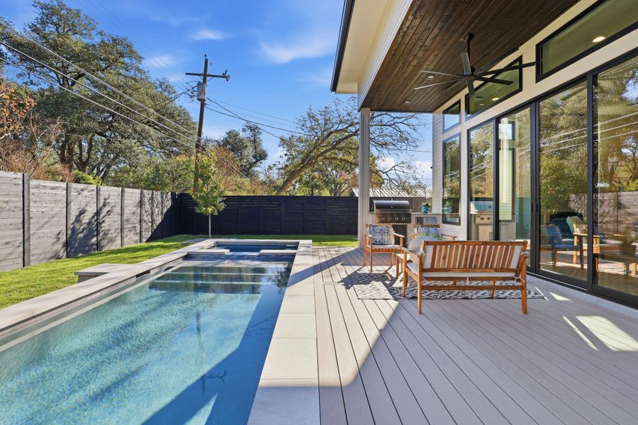 Deck featuring ceiling fan, a fenced backyard, a pool with connected hot tub, and grilling area