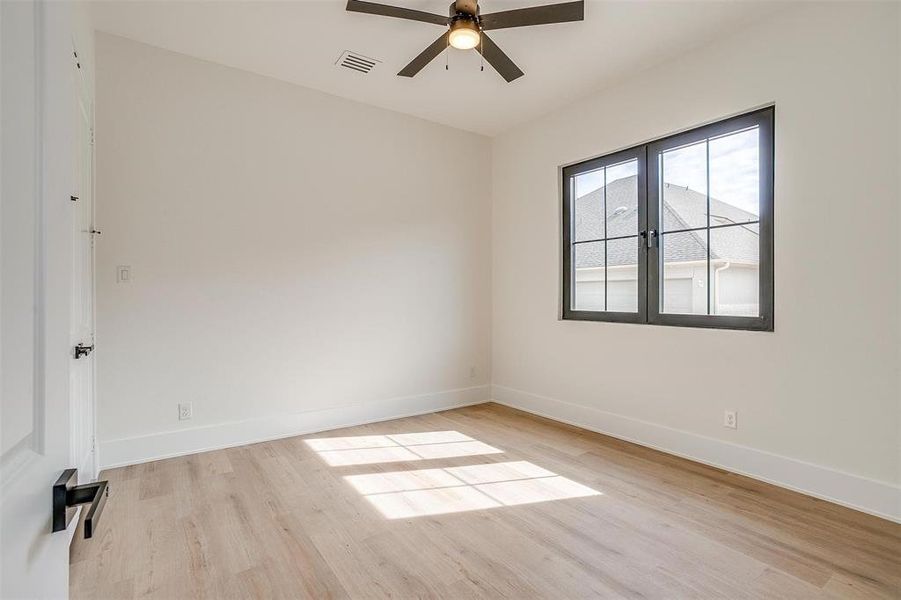 Empty room featuring visible vents, a ceiling fan, light wood-type flooring, and baseboards