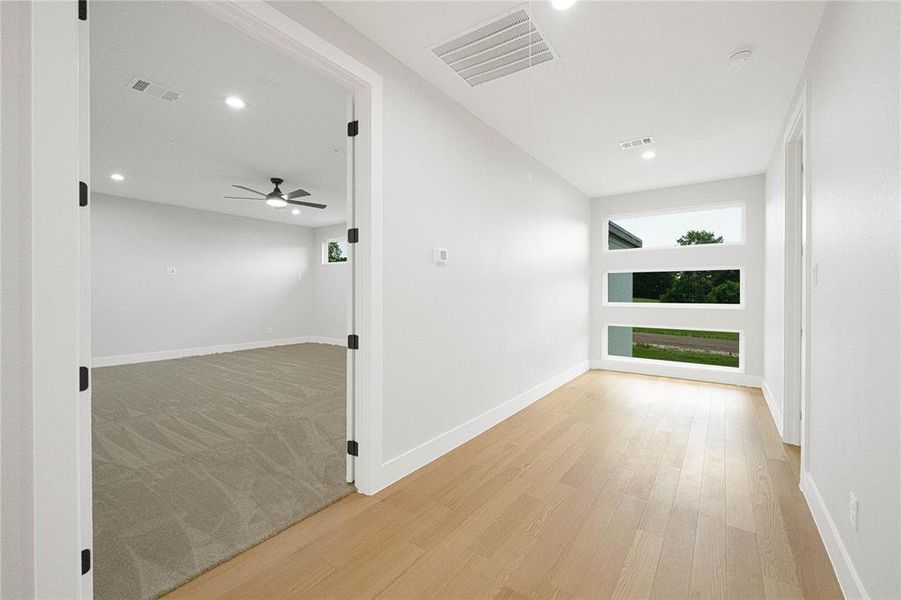 Corridor with light wood finished floors and recessed lighting
