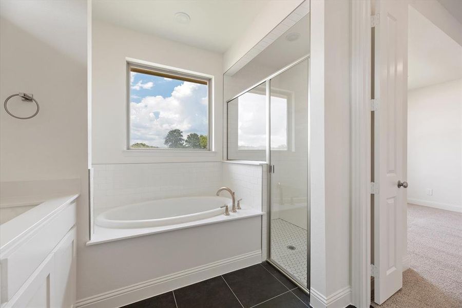 Bathroom featuring tile patterned flooring and independent shower and bath