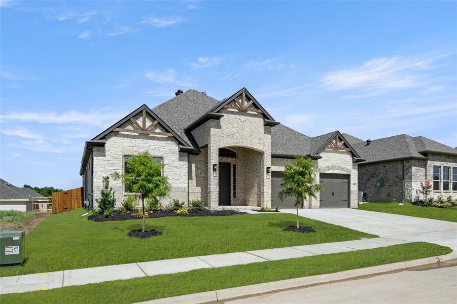 French country style house featuring concrete driveway, stone siding, roof with shingles, and brick siding French country style house featuring concrete driveway, stone siding, roof with shingles, and brick siding