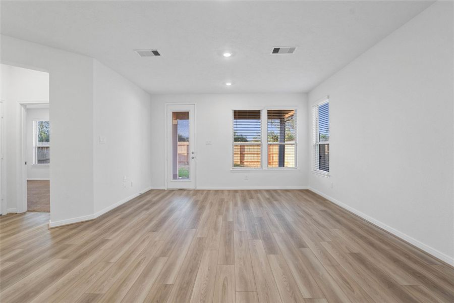 This bright and airy Great Room offers a spacious layout ideal for both relaxing evenings and lively gatherings. Designed for comfort and connection, it features Layton Lake vinyl plank flooring in Lighthouse, large windows, high ceilings, recessed lighting, and seamless access to the stunning kitchen—perfect for everyday living and entertaining alike.