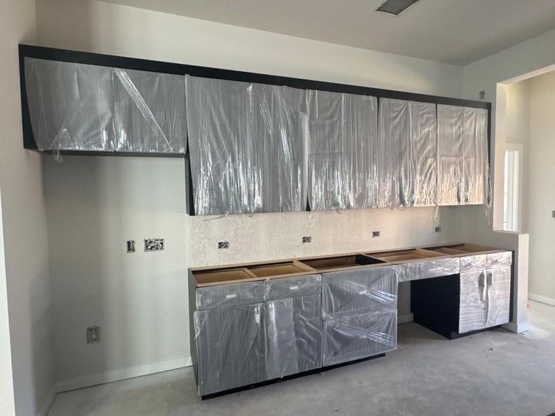 Kitchen featuring concrete flooring and tasteful backsplash Kitchen featuring concrete flooring and tasteful backsplash