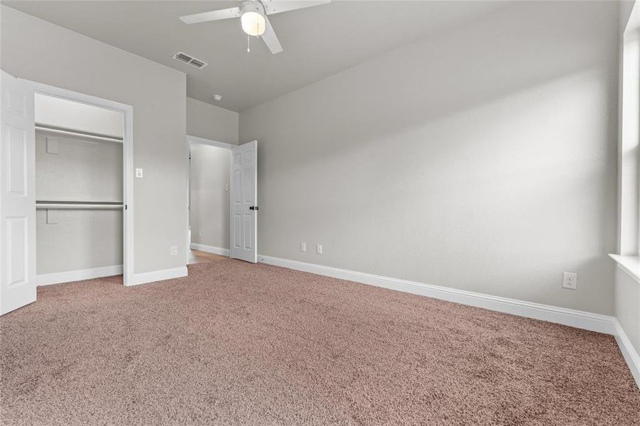 Unfurnished bedroom featuring light carpet, a closet, and ceiling fan