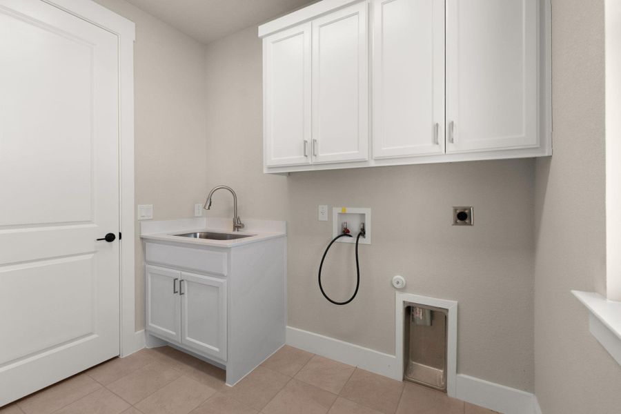 Laundry room with cabinet space, washer hookup, electric dryer hookup, light tile patterned floors, and hookup for a gas dryer
