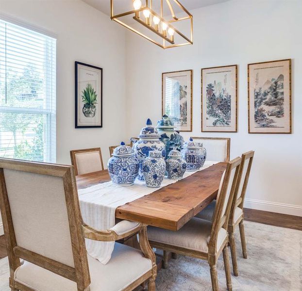 Dining area with wood-type flooring and an inviting chandelier