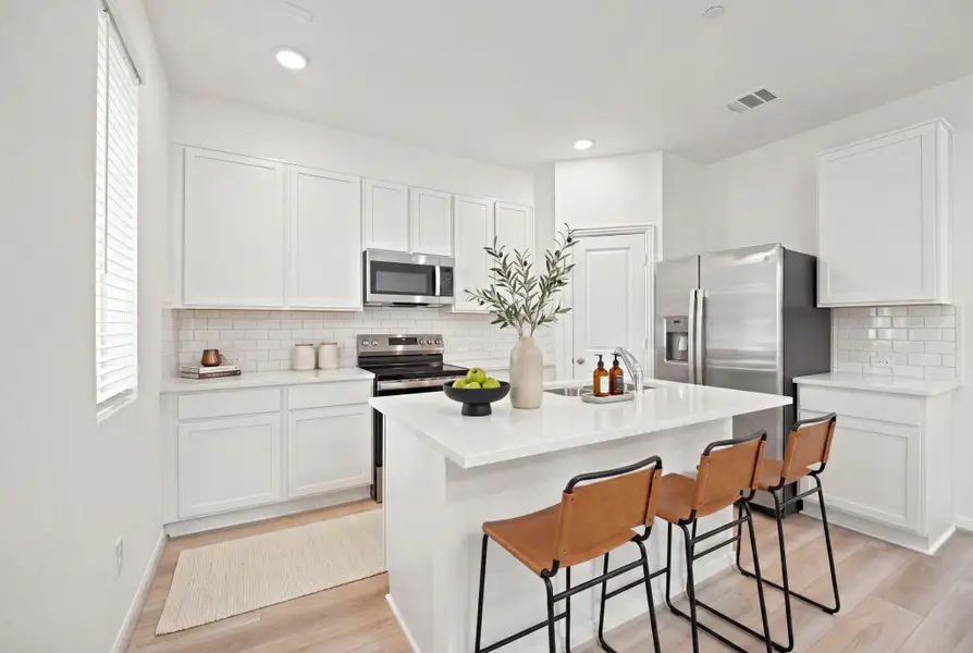 Recessed lighting and hard surface flooring elevate this contemporary kitchen design.
